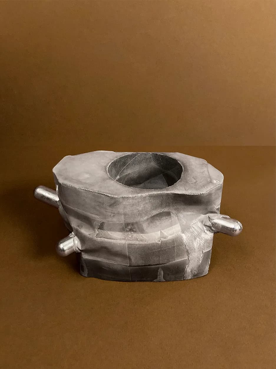 Right Angles — an octagonal concrete vessel with two chrome rods, unplanted