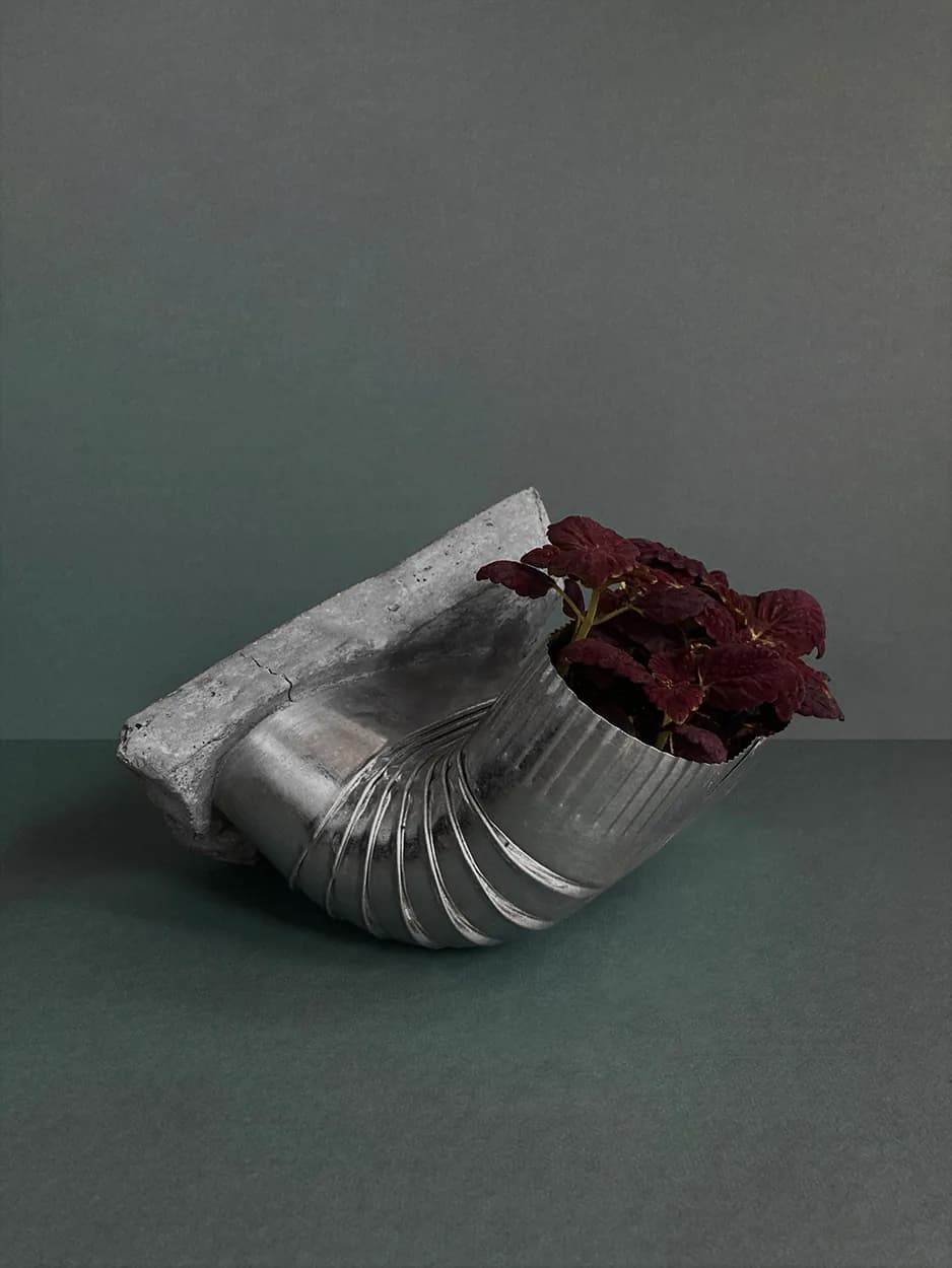 Beautiful Compromise — a concrete vessel fused with a corrugated metal spout, planted