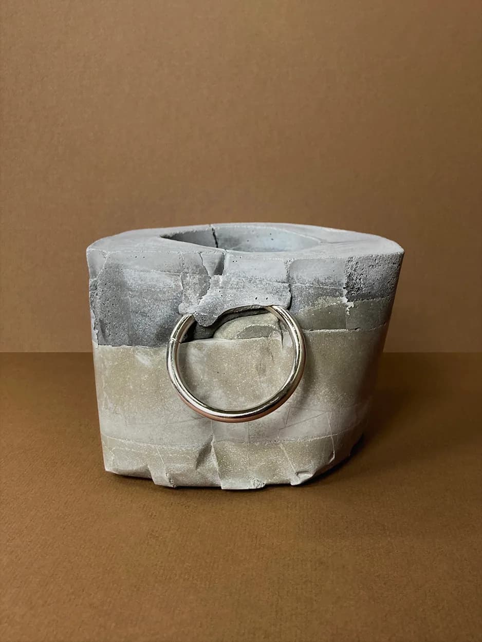Kinky Planter #10 — a faceted concrete vessel with a single ring, unplanted