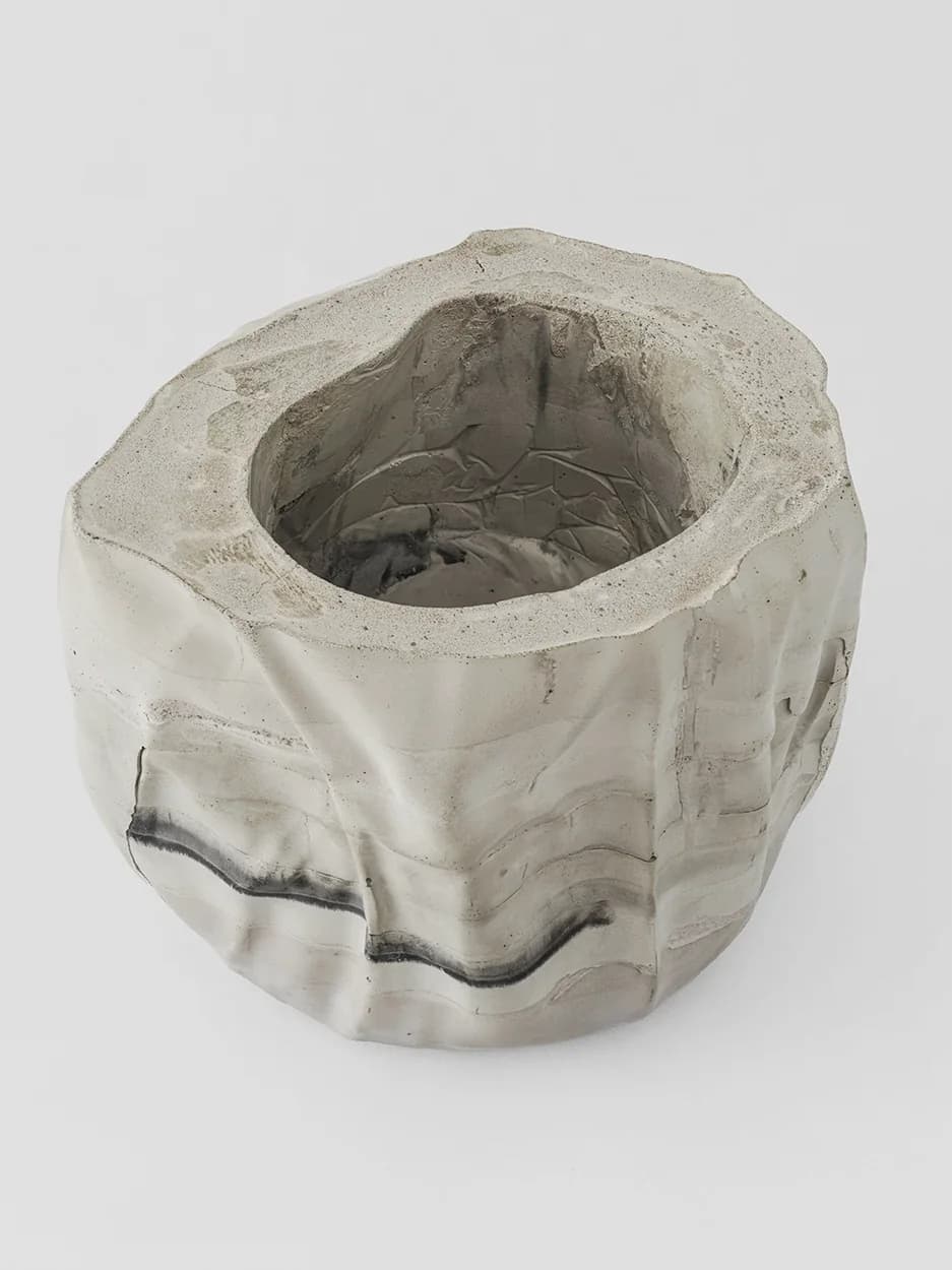 single line — a hand-formed concrete vessel, banded with a single dark line